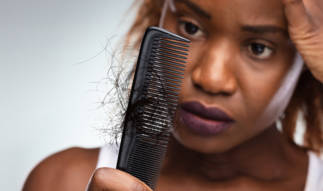Woman looking at hair shed on comb